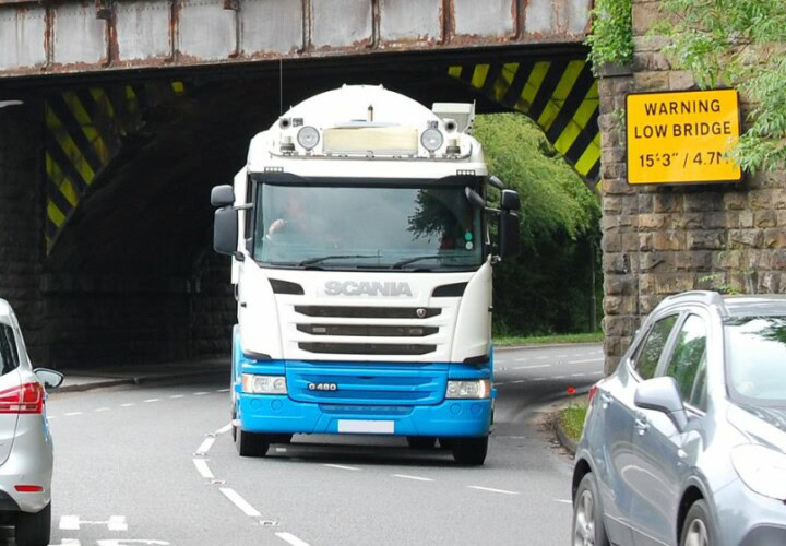 low bridge warning with lorry driving beneath it