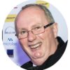 Microlise logistics technology conference speaker at a corporate event, smiling and wearing glasses.