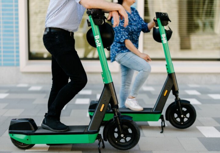 2 people riding bolt scooters