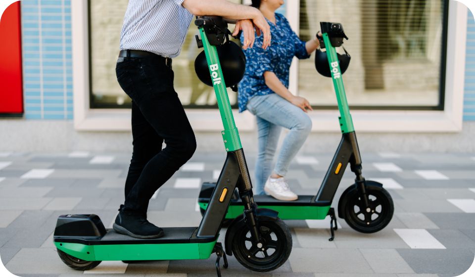 2 people riding bolt scooters