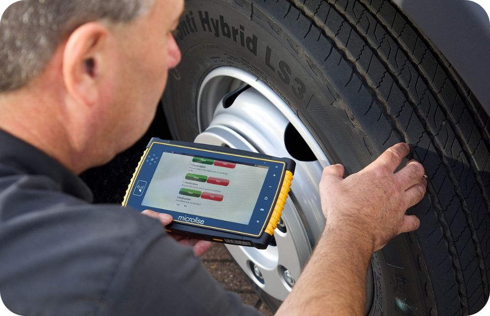 man using microlise drivetab telematics device to do vehicle walk around checks