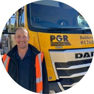 Image of a smiling man standing beside a yellow construction truck with Microlise branding, highlighting fleet management and telematics solutions for construction and logistics industries.