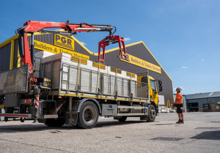 FASSI crane lifting palletized building materials at PGR Builders & Timber Merchants depot.