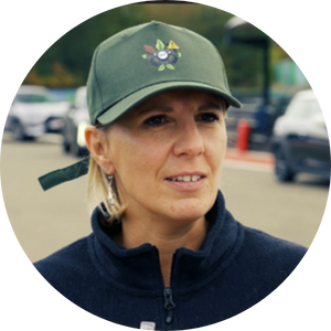 Advanced fleet management woman wearing a cap, outdoor parking lot, Microlise logistics solutions, transportation technology, driver safety, fleet optimisation, telematics, vehicle tracking, supply chain management, transportation software.