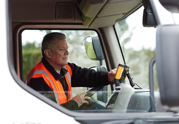 1. Truck driver using Microlise fleet management system to optimise routes and improve logistics efficiency.