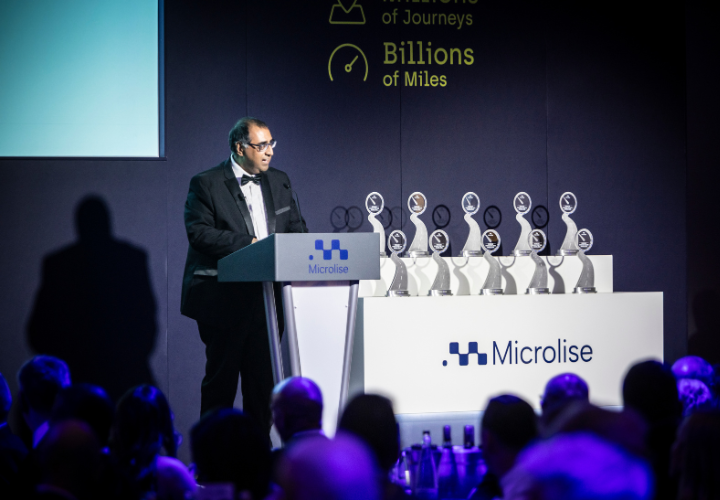 Award ceremony at Microlise celebrating the 2026 Driver of the Year shortlist with trophies on stage and a speaker presenting.